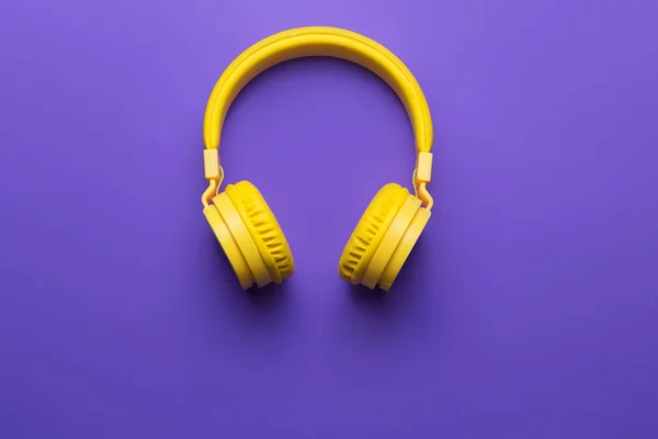 Yellow headphones on purple background. Music concept