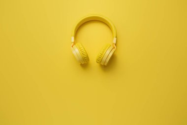 Sarı zemin üzerine sarı kulaklıklar. Müzik konsepti.