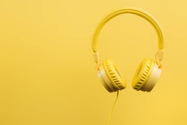 Sarı zemin üzerine sarı kulaklıklar. Müzik konsepti.
