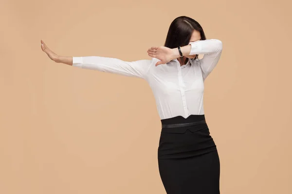 Fröhliche anonyme junge moderne Geschäftsfrau tanzt über beigen Hintergrund. Erfolgs- und Siegerkonzept. — Stockfoto