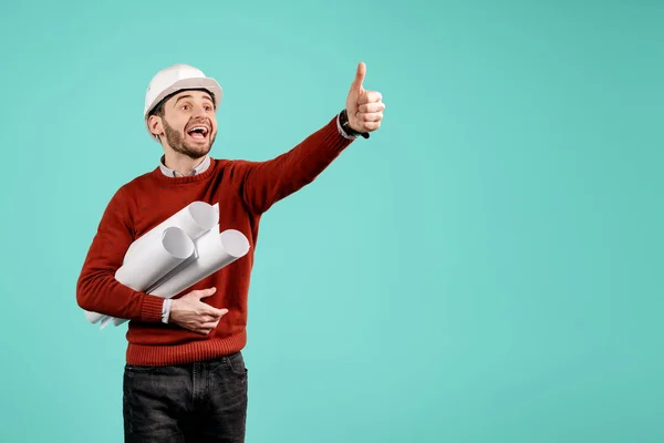 Aantrekkelijke jonge knappe baard engineer of constructeur man in Casual outfit show OK gebaar over cyaan achtergrond. Architectuur en renovatieconcept. — Stockfoto