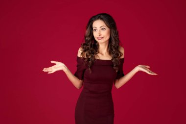Kırmızı arka plan üzerinde Maroon elbise mutsuz genç kadın fotoğrafı.