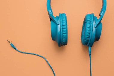 Yakın çekim fotoğraf bej renkli arka plan üzerinde şık modern mavi mavi kulaklık.