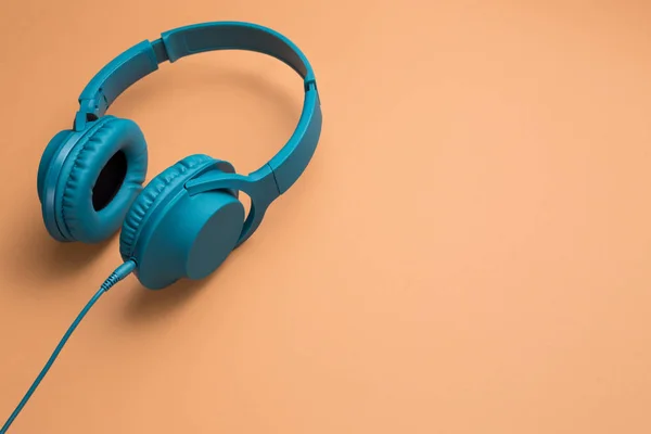 Foto de elegantes modernos fones de ouvido ciano azul sobre fundo bege — Fotografia de Stock