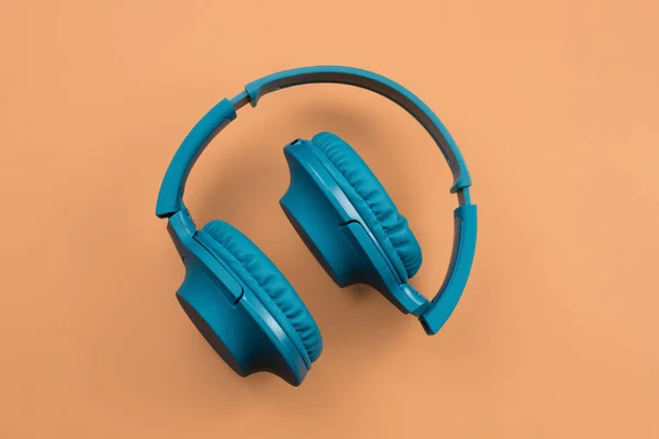 图为时尚的现代蓝色青色耳机在米色背景。顶视图. — 图库照片