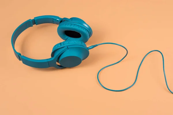 Photo of stylish modern blue cyan headphones over beige background — Stock Photo, Image