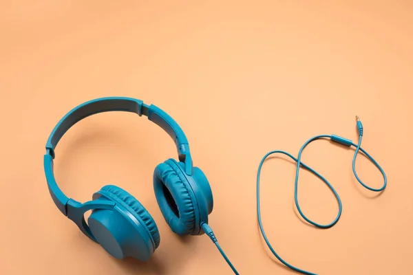 Fotografie stylových moderních modrých azurových sluchátek na béžovém pozadí — Stock fotografie