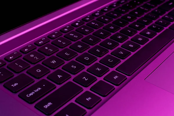 Foto in primo piano di elegante computer moderno o notebook in luce al neon . — Foto Stock