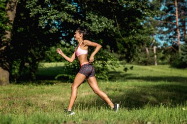 Genç kadın atlet açık egzersiz sırasında bir parkta koşu. Güzel kız uygun. Kilo kaybı. Spor yaşam tarzı.