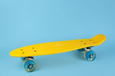 Mavi arka plan üzerinde Fotoğraf sarı kaykay veya pennyboard. Kopyalama alanı.