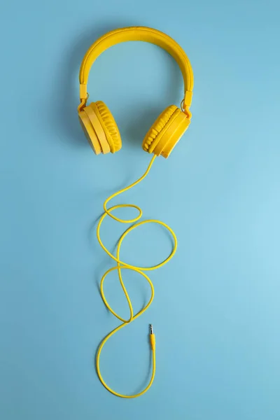 Cuffie gialle su sfondo blu. Concetto musicale . — Foto Stock