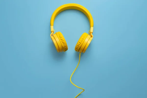 Mavi arka planda sarı kulaklıklar. Müzik konsepti.
