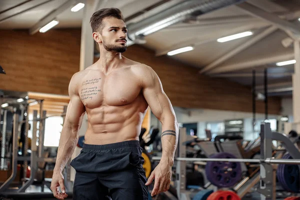 有吸引力的肌肉运动年轻男子健美健身模型在健身房锻炼后摆姿势. — 图库照片