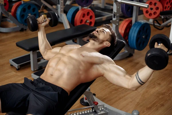 Kas yığını atletik genç adam vücut geliştirici beden eğitimi mankeni göğüs, spor salonunda halterli. Üst görünüm.