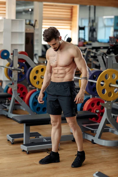 Attraktiv, muskuløs, ung mannskroppsbygger som poserer etter trening i gym . – stockfoto