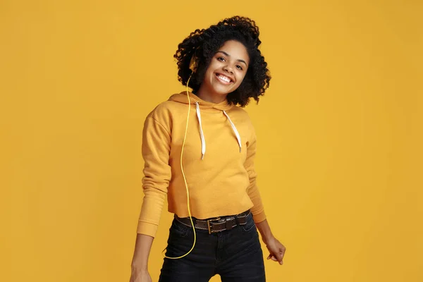 Glada afrikanska amerikanska ung kvinna med vackra leende klädd i casual kläder över gul bakgrund. — Stockfoto