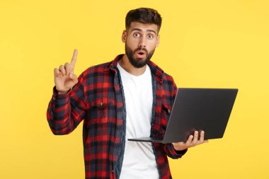 Heyecanlı sakallı hippi. Ekose gömlekli genç. Elinde not defteri var..