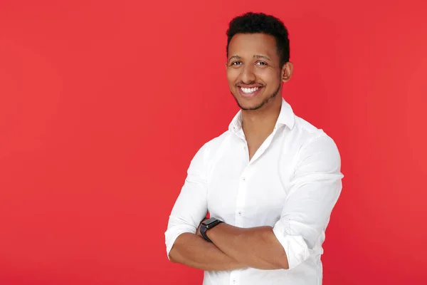 Kırmızı arka planda duran kendinden emin Afro-Amerikan genç adam..