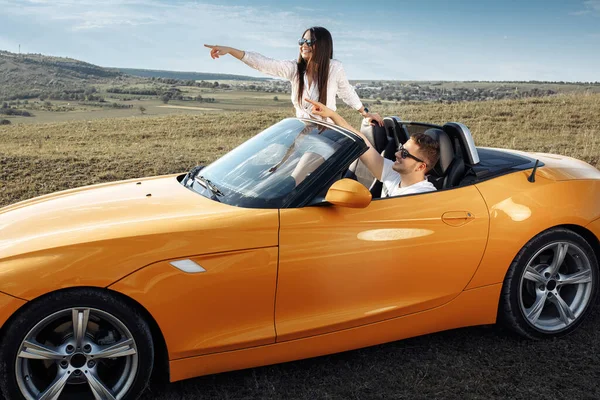 Mutlu genç çift gün batımında üstü açık bir arabayla uzun bir yolculuğa çıkıyor. Macera, seyahat ve aşk konsepti.