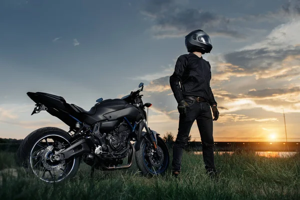 Cykel och motorcykel i solnedgången på landsvägen. — Stockfoto