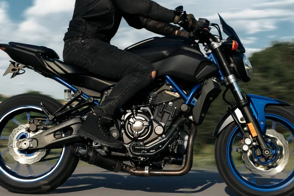 Primer plano de la foto en movimiento de motociclista de conducción de la motocicleta en la puesta del sol en la carretera del campo. —  Fotos de Stock