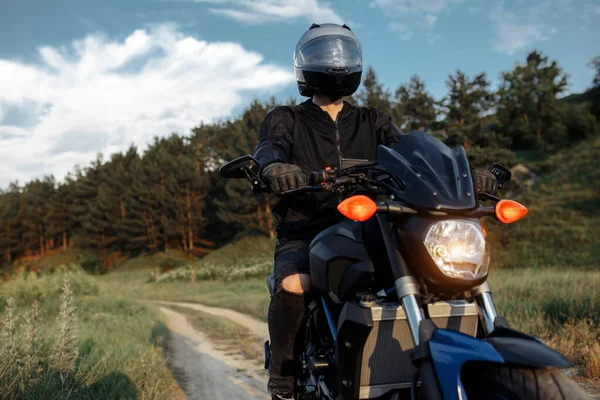 Foto de motociclista conduciendo motocicleta al atardecer en la carretera del campo. —  Fotos de Stock