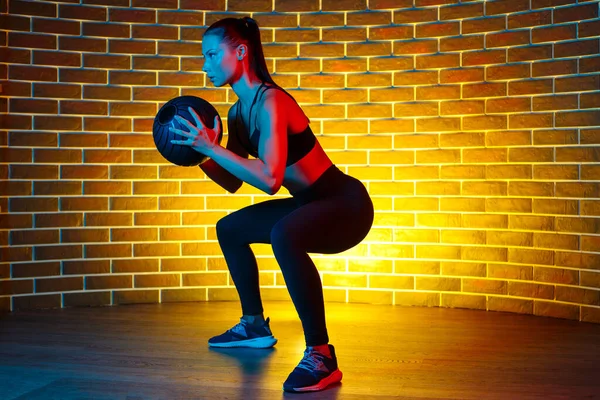 Formda, esmer bir kadın spor salonunda neon ışıklarla spor yapıyor.. — Stok fotoğraf