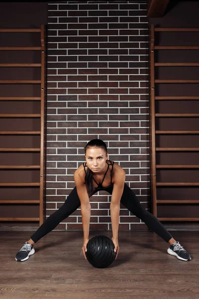 Güzel fit, genç esmer kadın spor salonunda tıp topu ile egzersiz yapıyor.. — Stok fotoğraf