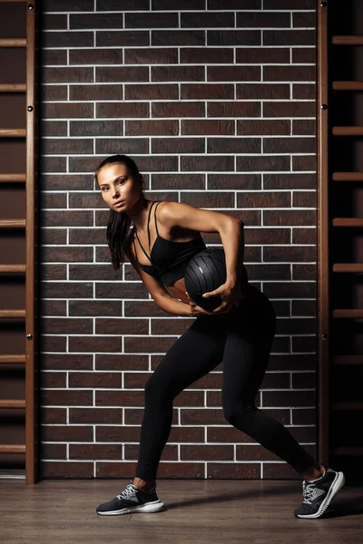 Attraente in forma giovane bruna donna esercizio con palla medica in palestra. — Foto Stock