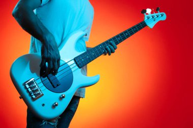 Neon ışıklarla beyaz bas gitar çalan şık bir hipsterın yakın-ip görüntüsü. Rock müzik konsepti.