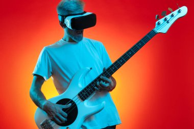 Modern hipster adam beyaz bas gitar çalıyor ve yüzünde vr kulaklığı var. Müzik konsepti. Sanal gerçeklik.