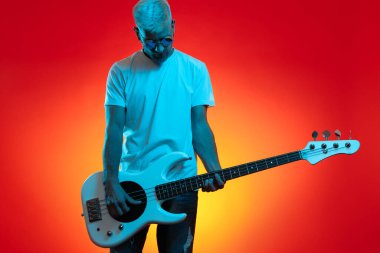 Modayı takip eden hippi, neon ışıklarda beyaz bas gitar çalıyor. Rock müzik konsepti.