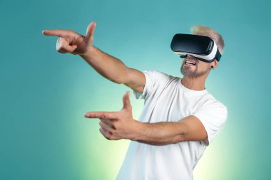 Sanal gerçeklik gözlüğü takan, sarı saçlı sakallı hippi bir adam. Stüdyoda neon ışıkları altında..