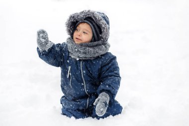 Sıcak beyaz kar takım elbiseli komik yüzlü komik bir çocuğun yakın plan görüntüsü..