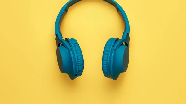 蓝色耳机在黄色背景上的特写图像。音乐概念. — 图库照片