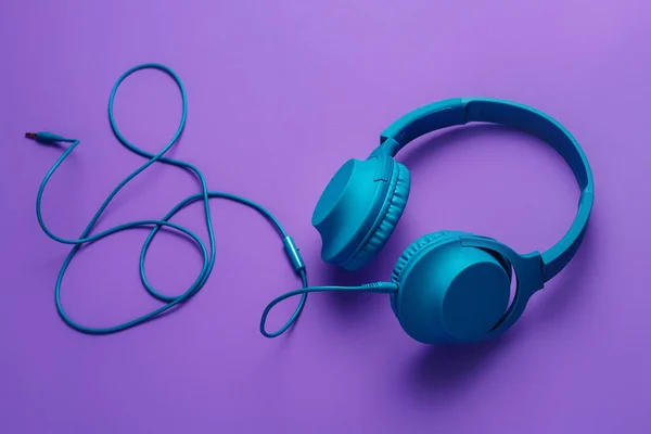 Modern blue headphone on purple background. Music concept. — Stock Photo, Image