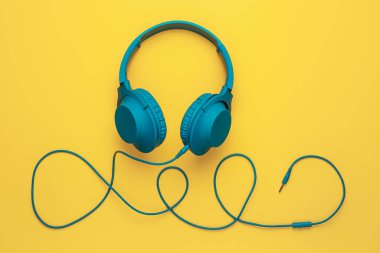 Sarı arka planda moda mavi kulaklık. Müzik konsepti.