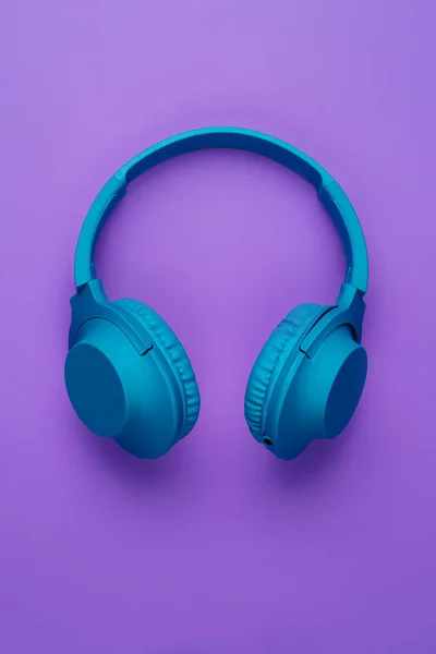 Cool blue wireless headphone on purple background. Music concept. — Stock Photo, Image