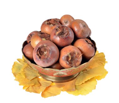 Metalik kase taze organik medlars/Mespilus germanica ile dolu / beyaz arka plan üzerinde izole 