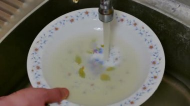 Kirli su lavaboya çanak üzerinde / kirli su akan musluk ve çanak üzerinde düşüyor