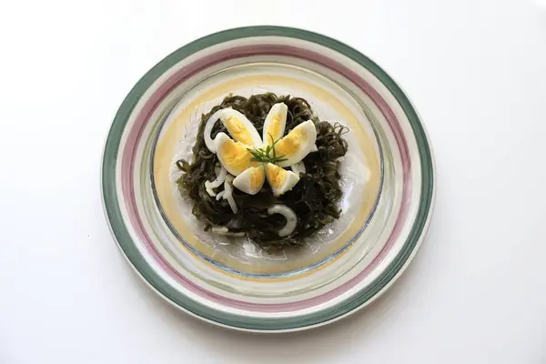 lezzetli lezzetli salata, haşlanmış yumurta ve soğan ile deniz kale.