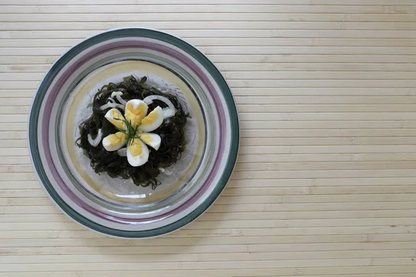 lezzetli lezzetli salata, haşlanmış yumurta ve soğan ile deniz kale.