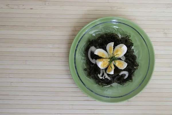lezzetli lezzetli salata, haşlanmış yumurta ve soğan ile deniz kale.