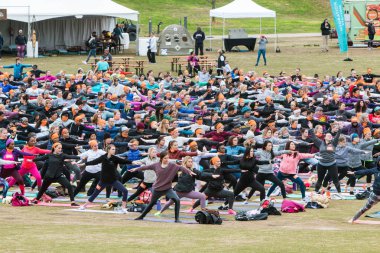 Atlanta, Ga, Amerika Birleşik Devletleri - 8 Nisan 2018: onlar Piedmont Park büyük grup yoga sınıfında 8 Nisan 2018 üzerinde Atlanta, Ga içinde yer almak gibi düzinelerce insan bir savaşçı poz sırım.