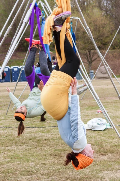 として彼らはピードモント公園の空中ヨガ クラスで 2018 日にジョージア州アトランタの極に接続されたファブリックを使用してダウン逆さまアトランタ ジョージア州 アメリカ合衆国 2018 若い女性ハング — ストック写真