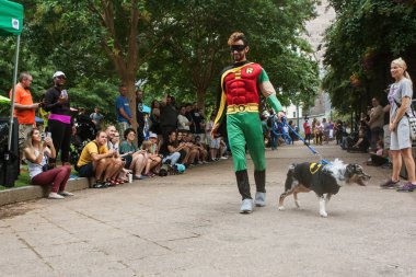 Atlanta, Ga, Amerika Birleşik Devletleri - 18 Ağustos 2018: Batman giyen onun köpek kostüm Doggy Con, Atlanta, GA 18 Ağustos 2018 Woodruff Park'ta bir köpek kostüm yarışması, kalabalık önünde Robin kostüm yürüyüşler giyen bir adam.