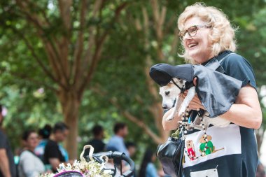 Atlanta, GA, USA - August 18, 2018:  A woman carries a small dog dressed like Darth Vader from Star Wars as she and her dog participate in Doggy Con, a dog costume contest in Woodruff Park on August 18, 2018 in Atlanta, GA.