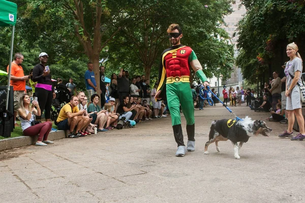 アトランタ ジョージア州 アメリカ合衆国 2018 衣装のロビン散歩犬コン 2018 日にジョージア州アトランタのウッドラフ パークで犬のコスチューム コンテストで大観衆の前で彼の犬を身に着けているバットマン衣装を着た男 — ストック写真