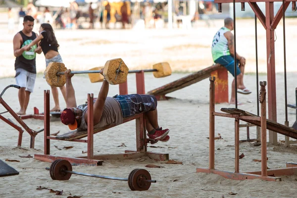 El hombre presiona el banco usando equipo crudo en el gimnasio al aire libre de Brasil —  Fotos de Stock