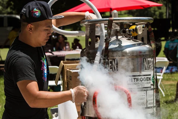 Mann füllt Krug bei Eisfestival mit flüssigem Stickstoff — Stockfoto